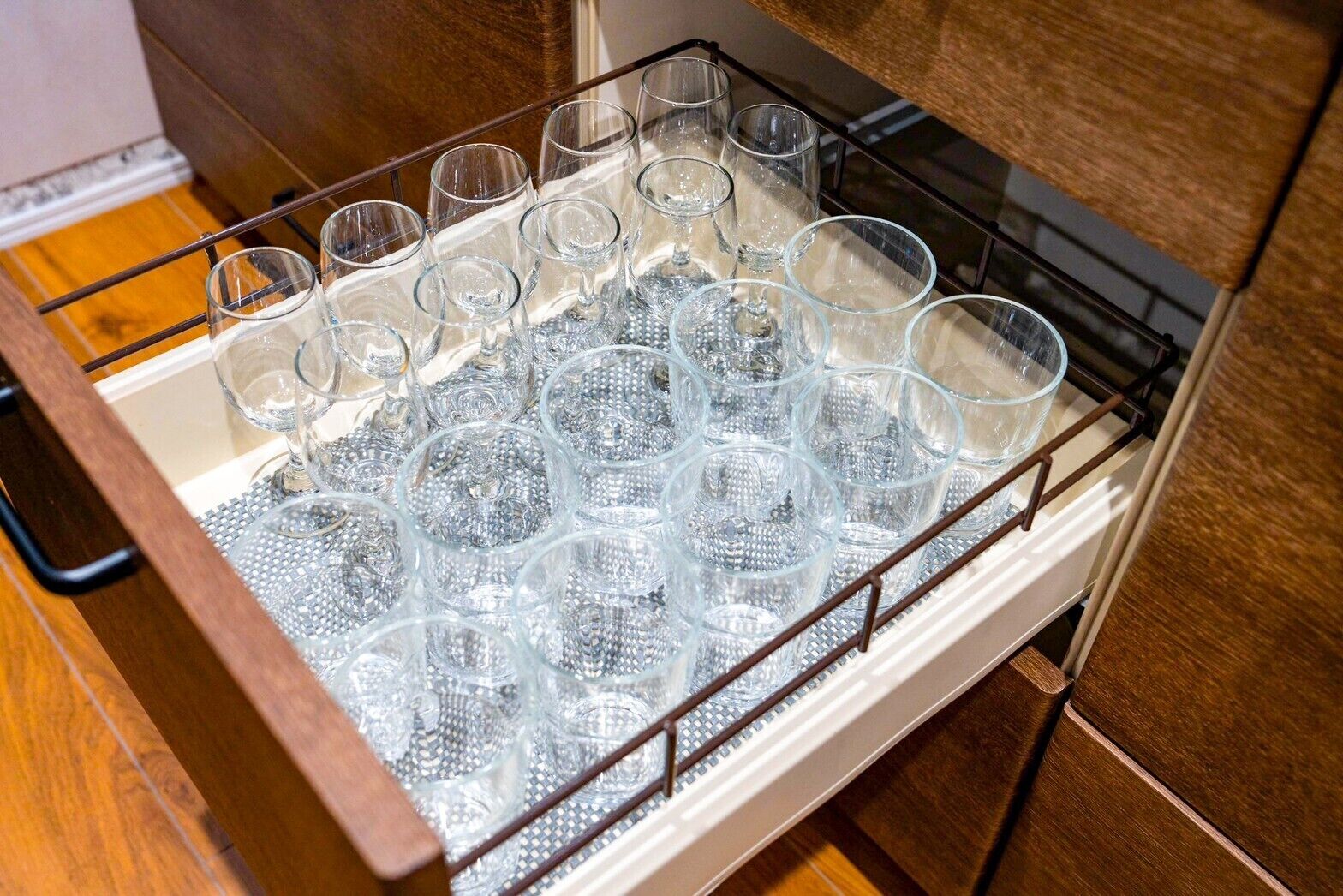 En skuffe med et glasorganisator, der indeholder flere glas.