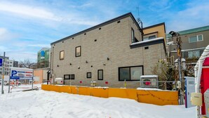 A modern building with a brick facade, a flat roof, and a visible satellite dish. - SHIRAKABA (Otaru)