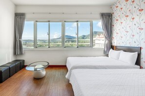 A hotel room with a large window, two beds, a glass coffee table, and a seating area with a sofa and armchairs. - Rich house (Hengchun)