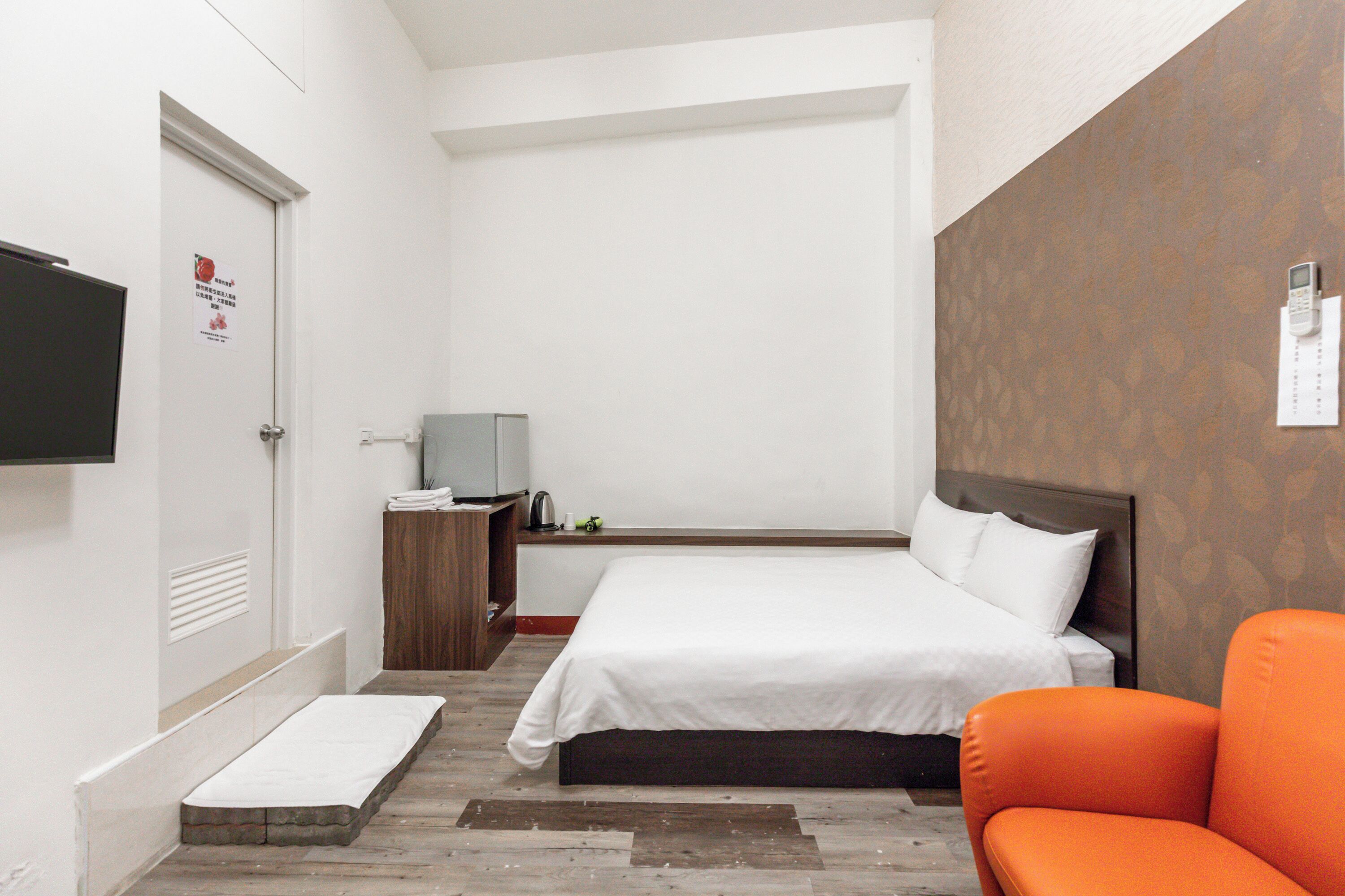 Ein Hotelzimmer mit einem Bett, einem Fernseher, einem Schreibtisch und einem Sessel.