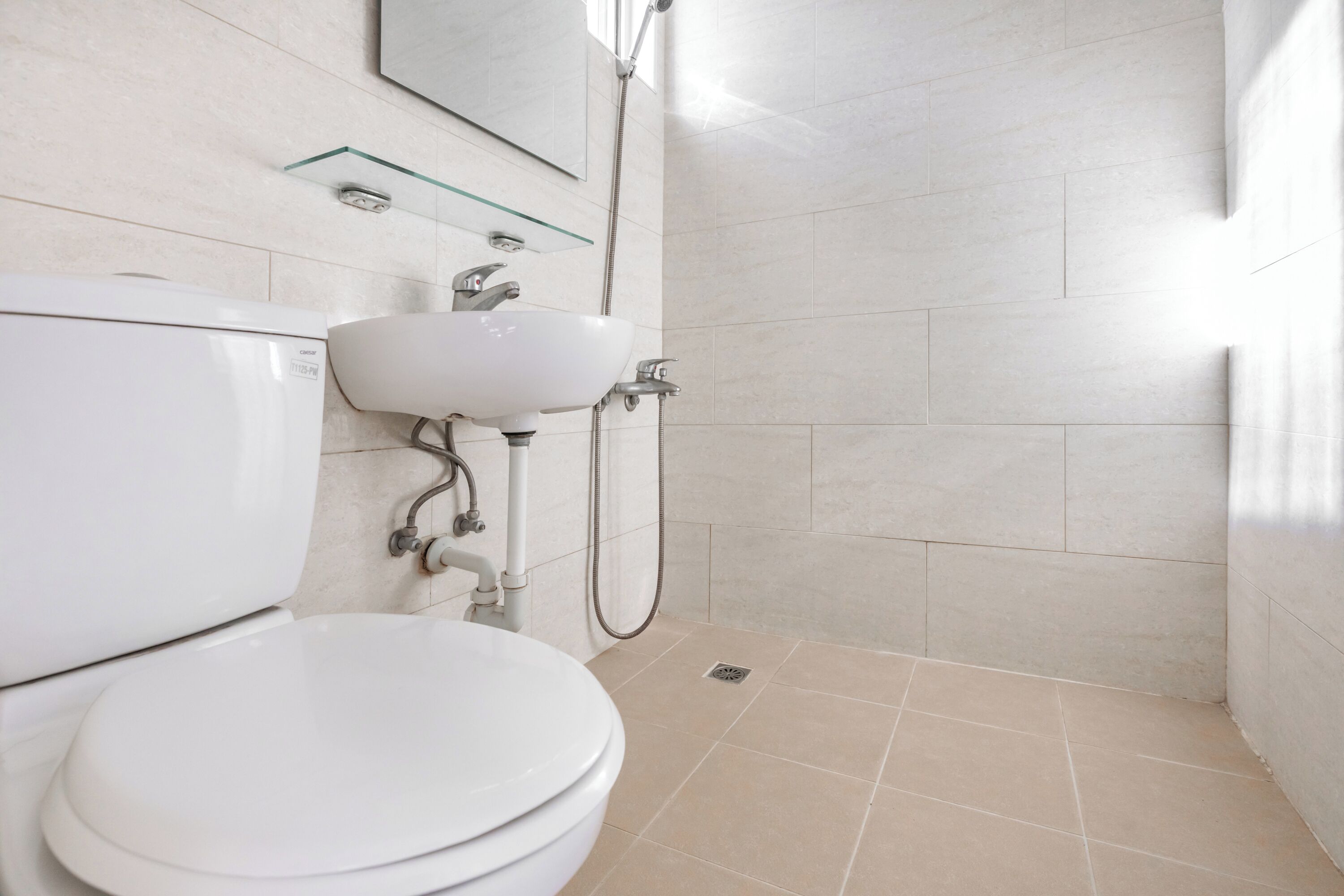 A modern bathroom with a toilet, sink, and shower.
