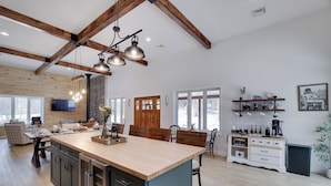A spacious kitchen with a large island, wooden beams, and pendant lighting. - Luxury Barndominium w/ Golf Sim, Hot Tub, Home Theater, Minutes to Jim Thorpe! (Jim Thorpe)