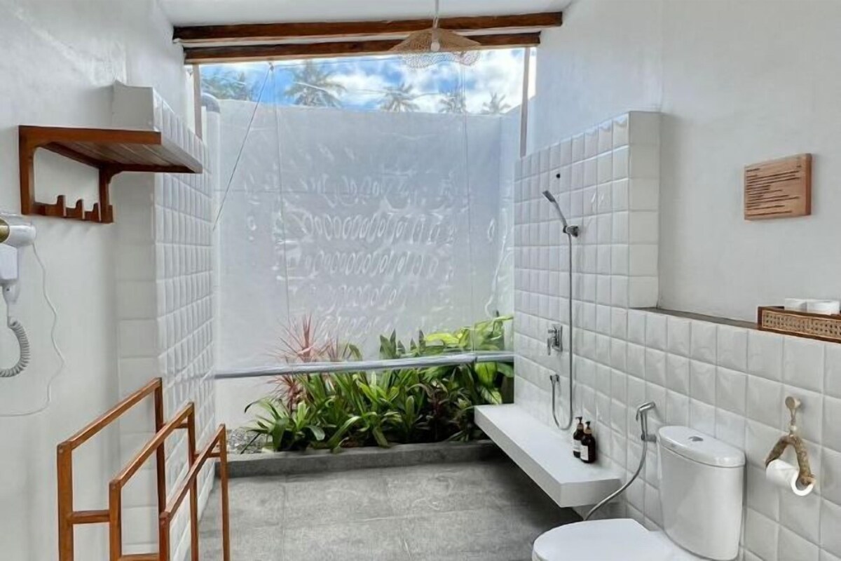 A compact bathroom with a shower, toilet, and sink.