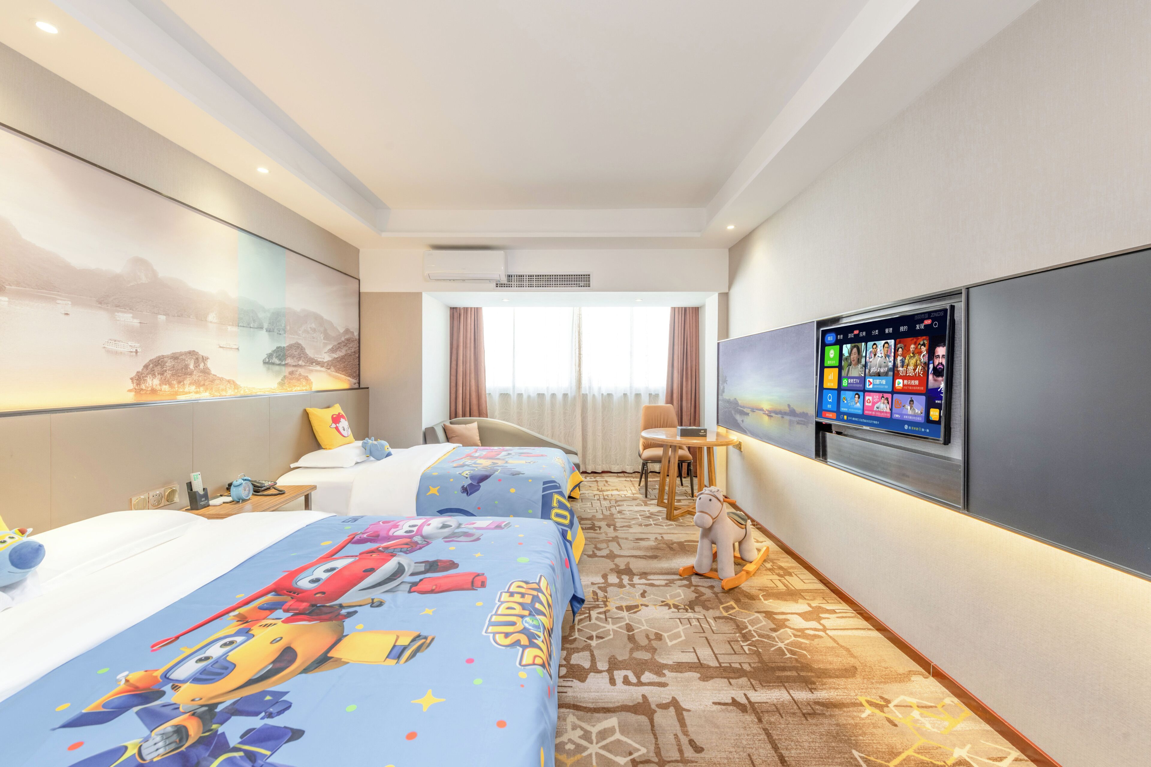 Habitación de hotel con dos camas, televisión, escritorio y un ventanal grande.