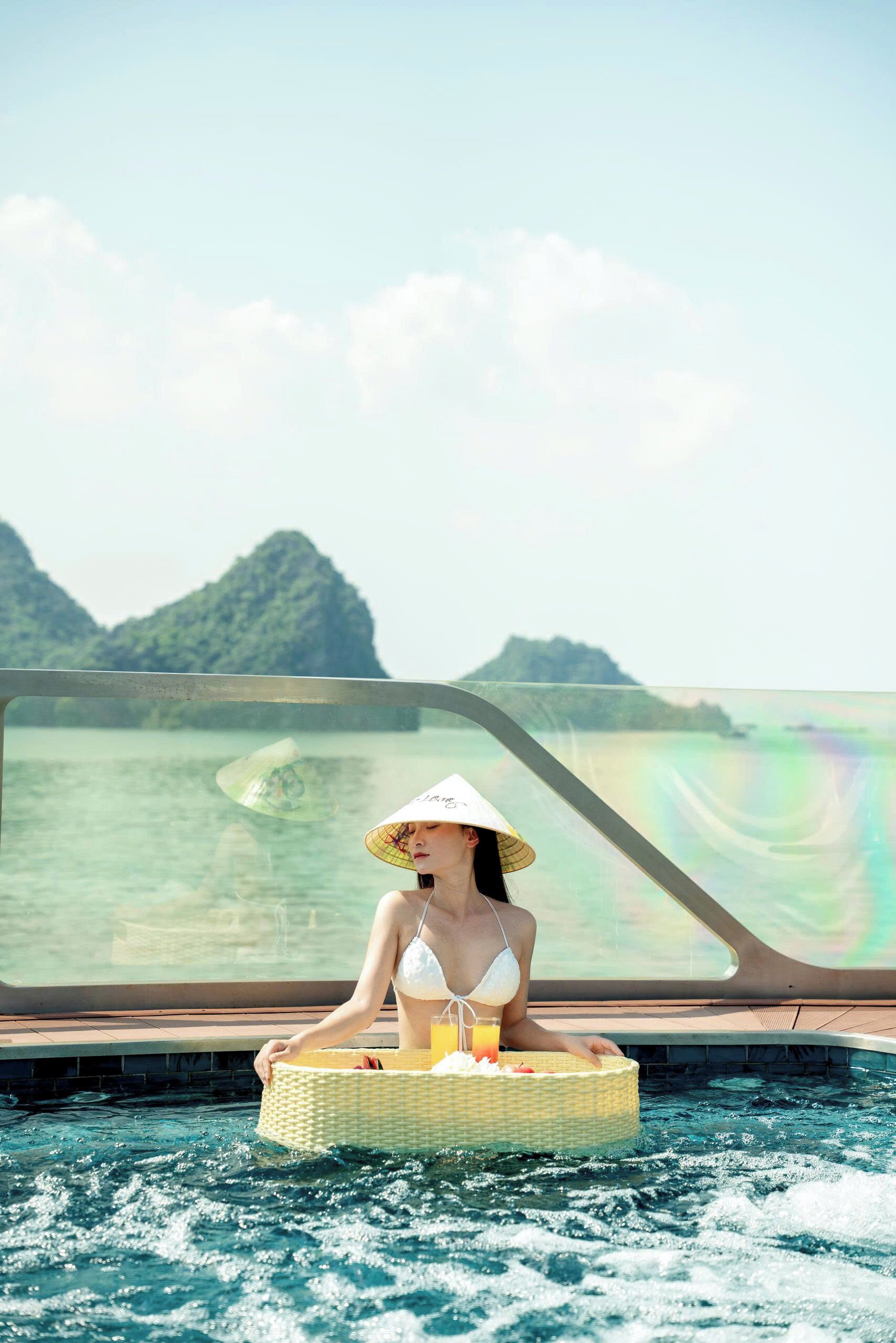Eine Person entspannt am Pool mit Blick auf eine gebirgige Landschaft.