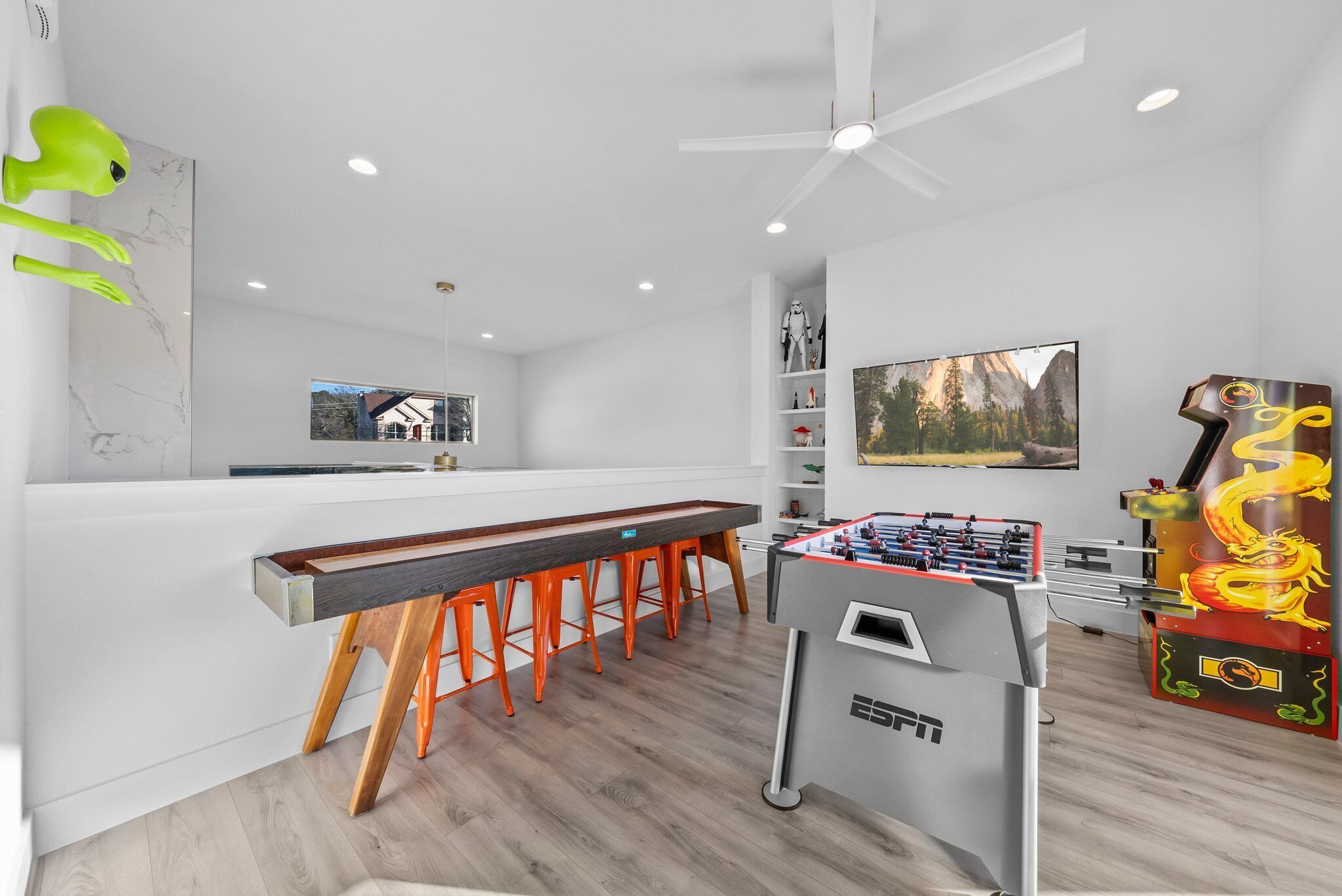 Een moderne keuken met een bar, een tafelvoetbaltafel en een groot raam met uitzicht op de bergen.