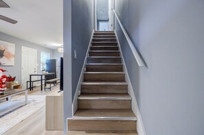 Staircase leads to a dining area with a table and chairs.