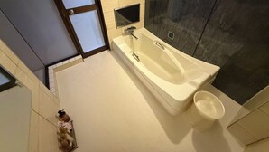 A modern bathroom with a freestanding bathtub, a glass shower enclosure, and a dark textured wall. - Sakura Osaka Castle North Hotel (Osaka)