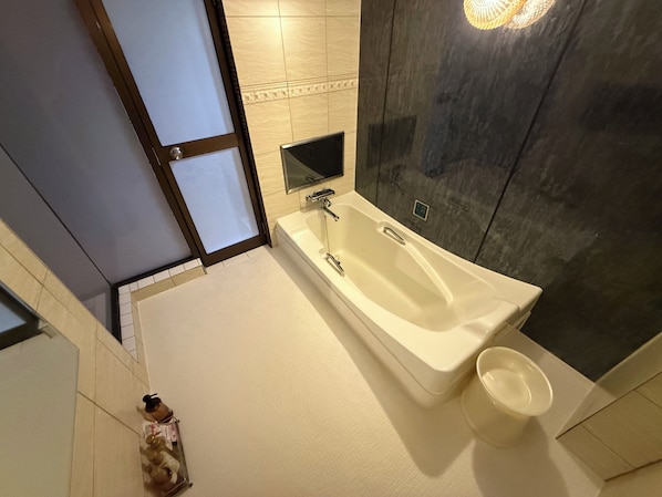 A modern bathroom with a freestanding bathtub, a glass shower enclosure, and a dark textured wall. - Sakura Osaka Castle North Hotel (Osaka)