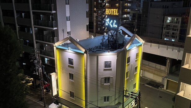 A multi-story hotel with a prominent sign indicating its name and a neon sign with Japanese characters. - Sakura Osaka Castle North Hotel (Osaka)