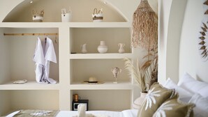 Ein Schlafzimmer mit einem Bett, Regalen mit Körben, einem Hut und einer kleinen Pflanze.