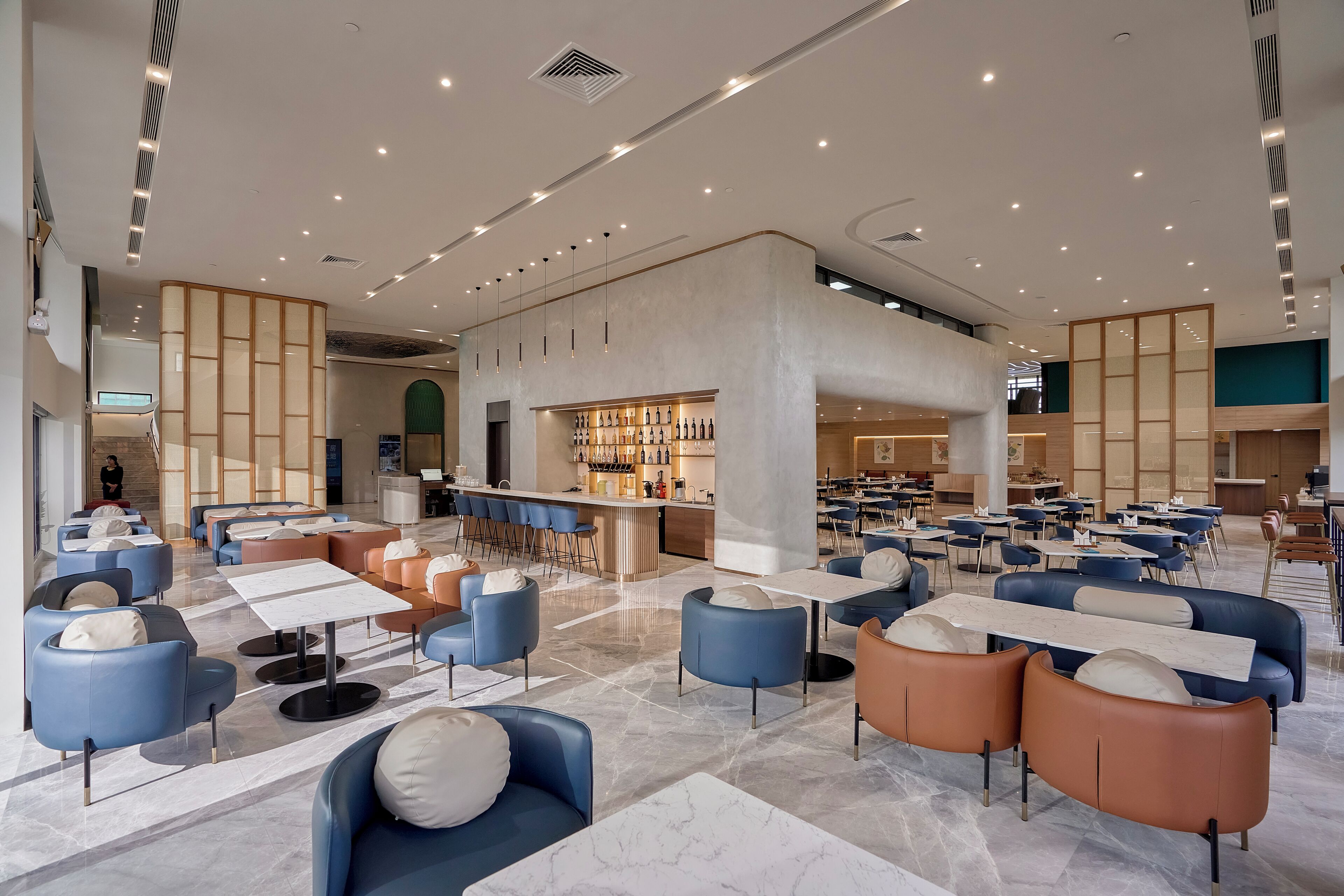 Eine geräumige Lobby mit Sitzbereichen, einer Bar und einem Restaurant.
