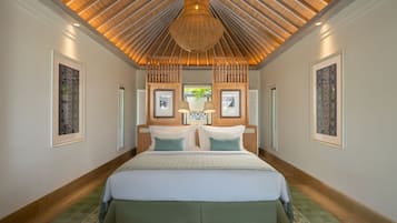 Ein geräumiges Schlafzimmer mit einem großen Bett, einer Holzbalkendecke und gerahmten Kunstwerken an den Wänden.