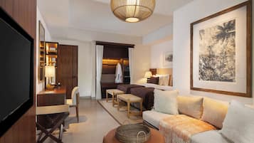 Ein modernes Hotelzimmer mit Fernseher, Sitzecke und Kunstwerken.