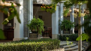 A covered outdoor area with stone steps, potted plants, and a patterned wall. - Sudamala Resort Ubud Bali (Ubud)