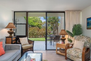 Una sala de estar con sofá, sillones, una mesa de centro y un comedor con sillas y mesa.