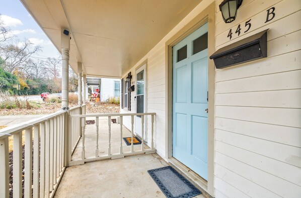 A porch with a blue door and a mailbox with the number 445 B.