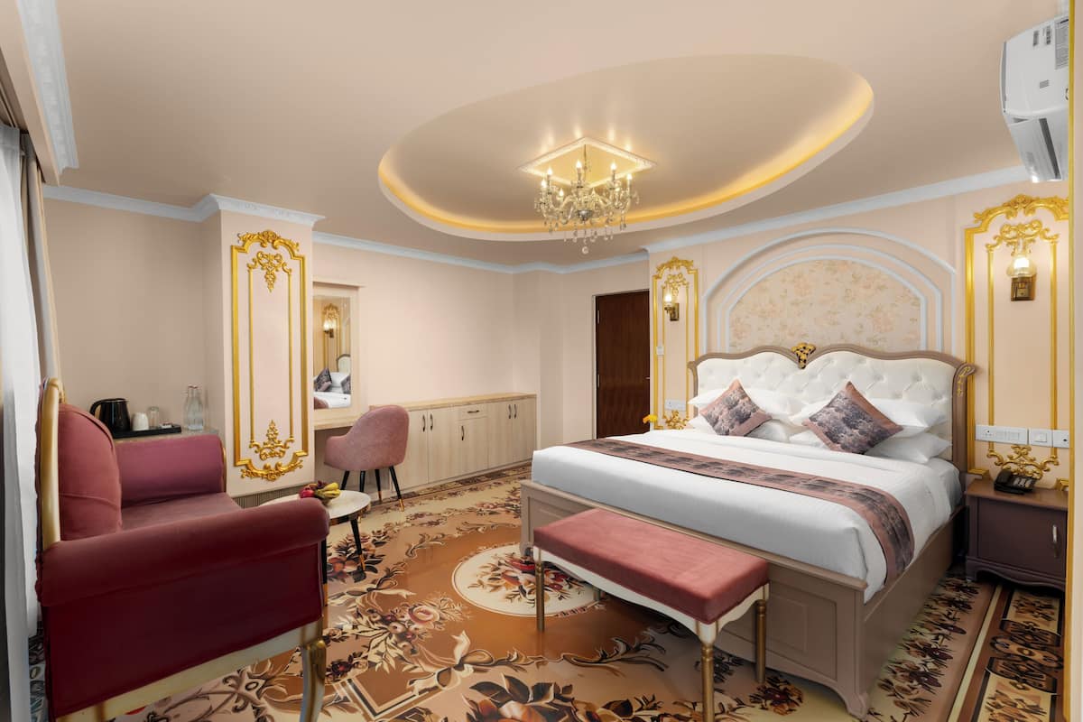 Una habitación de hotel con una cama grande, un escritorio, una silla y una pequeña mesa.