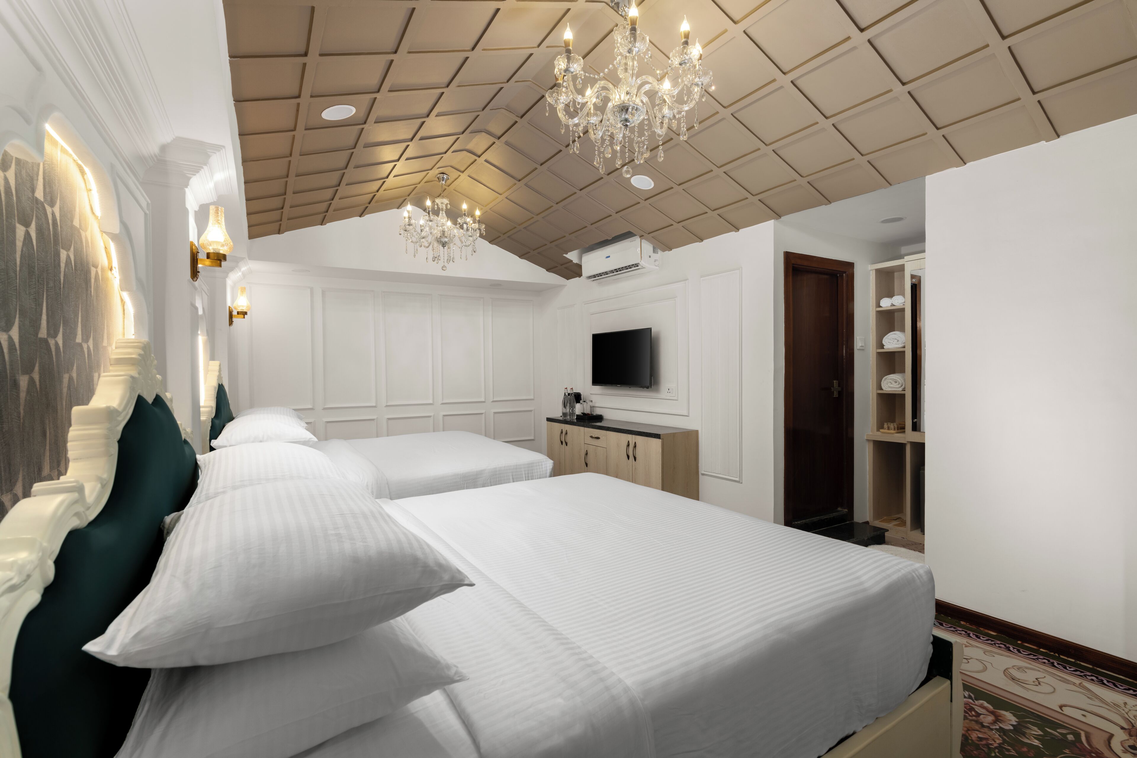Una habitación de hotel con una cama grande, televisión y un candelabro.