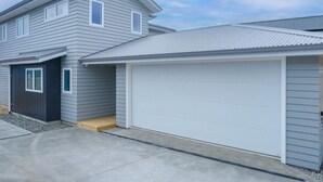 Et toetagers hus med garage og en overdækket indgang.