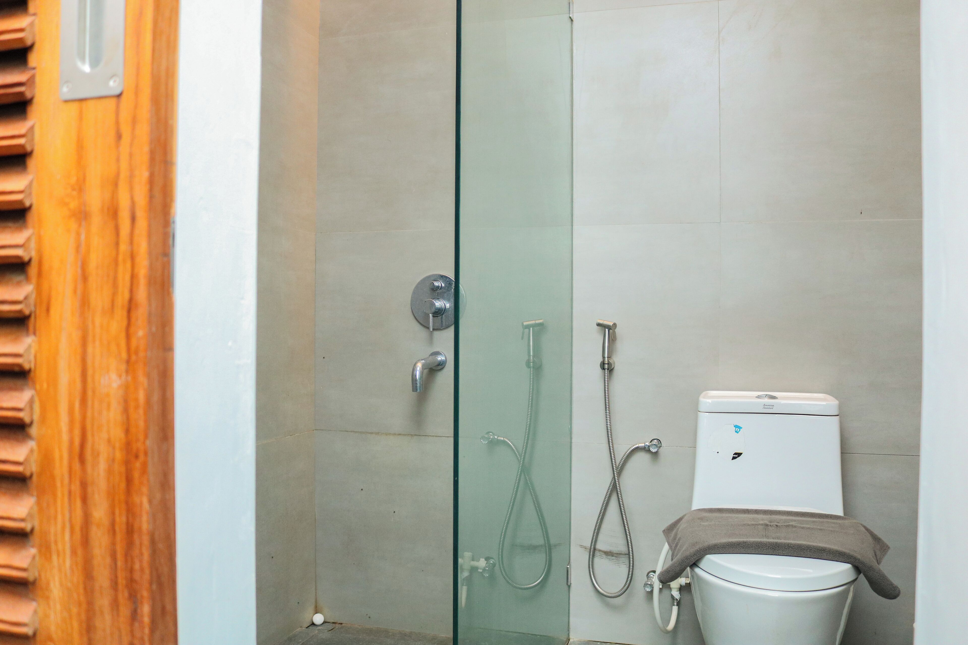Un baño con cabina de ducha de vidrio, inodoro y ducha.