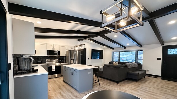 A modern kitchen with a central island, built-in appliances, and a dining area with a round table.