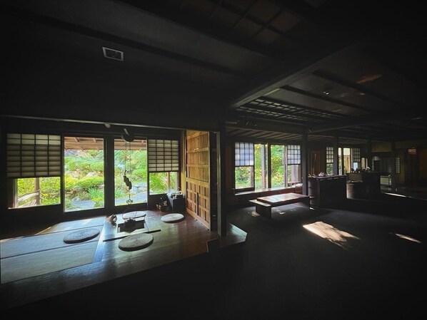 A traditional Japanese room with tatami flooring, sliding doors, and large windows overlooking a garden. - WATAYA (Hakusan)