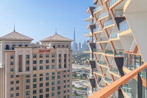 A Marriott hotel with a classic architectural style, featuring a central dome and two smaller domes. The hotel is surrounded by modern high-rise buildings and a clear view of the city skyline. - Skyline Views Binghatti Avenue (Dubai)