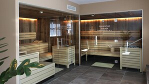 A sauna room with wooden benches and a glass partition. - Apartment with shared wellness and fitness (Piesendorf)