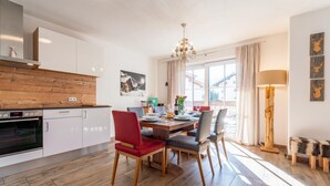 A modern kitchen with white cabinets, a wooden countertop, and a built-in oven. - Cosy apartment with a large balcony and wellness (Piesendorf)