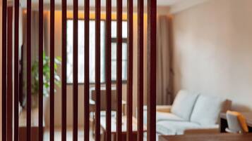 A blurred view of a room with a sofa and a table, through vertical wooden slats.