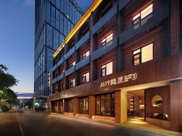 A modern building with a prominent sign for Hidden Chunguan Inn. - Chengdu Chuanxing Yinli Hotel (Chengdu)