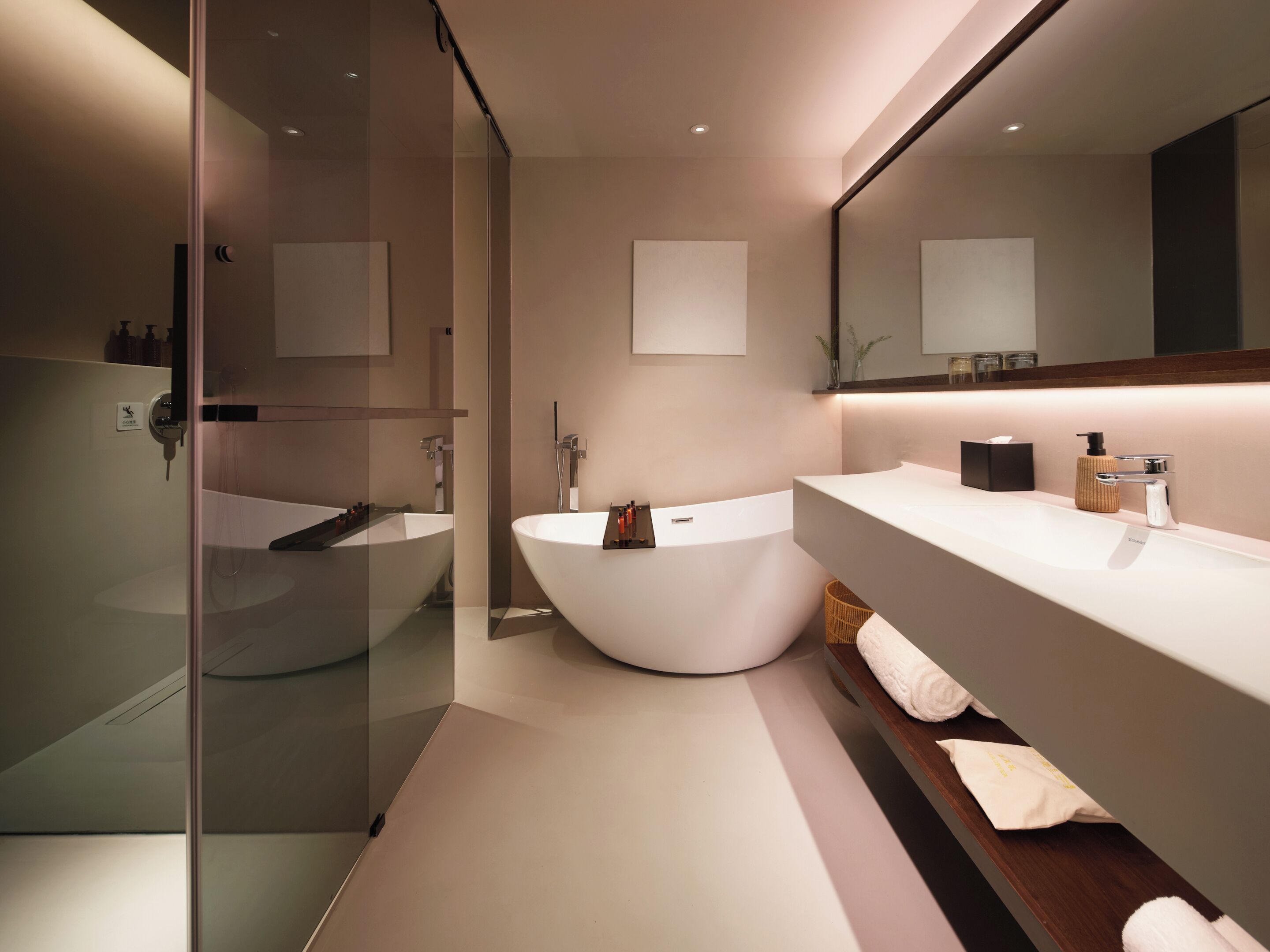A modern bathroom with a freestanding bathtub, a large mirror, and a glass-enclosed shower area.