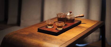 A wooden table with a tray holding a teapot and two cups.