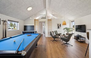 Relax in a spacious room with a pool table, comfortable seating area, and large window offering a view.