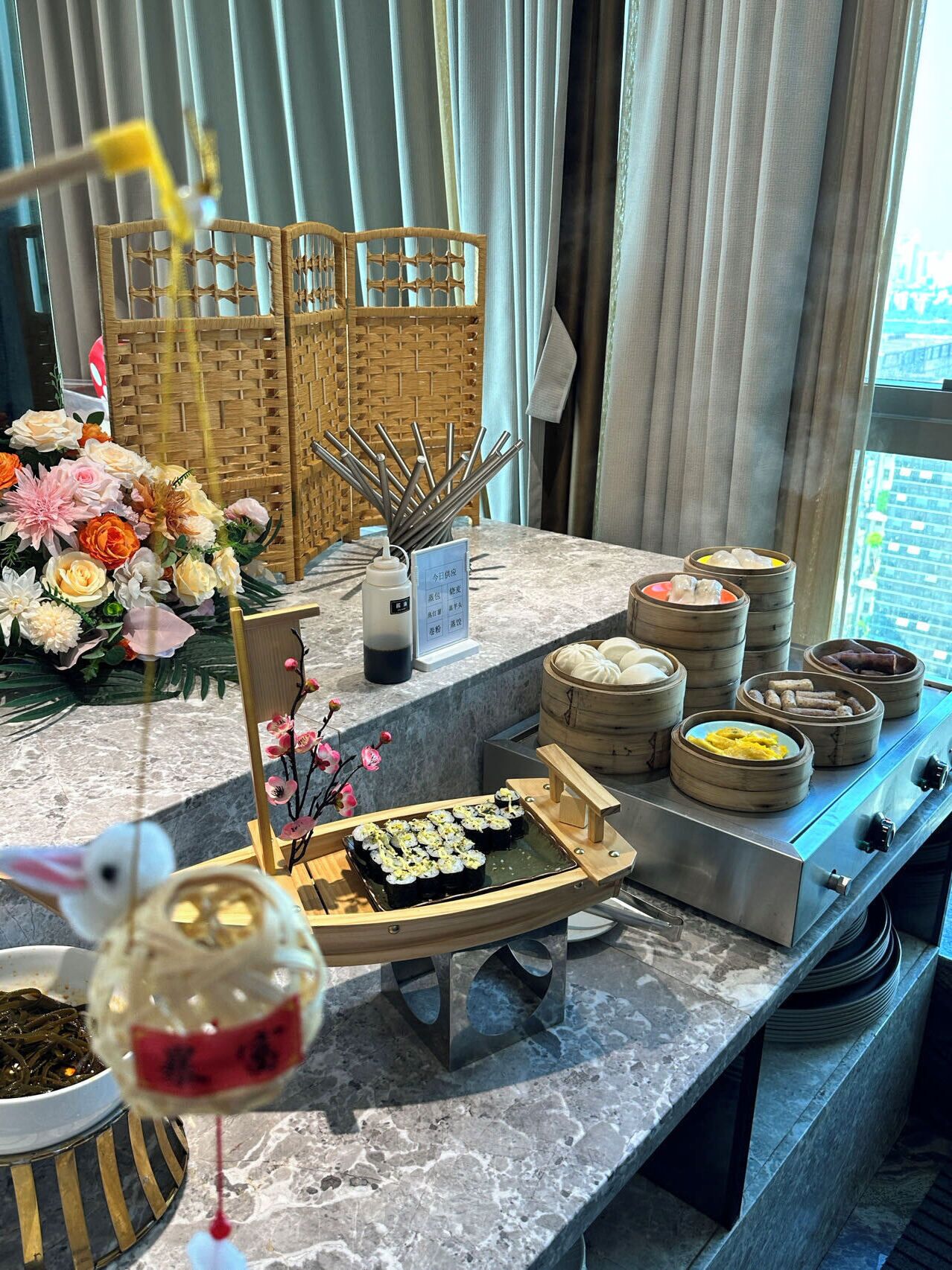 Un buffet proposant une variété de plats, notamment des sushis, des raviolis et un assortiment de boissons.