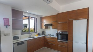 Una cocina moderna con armarios de madera, electrodomésticos de acero inoxidable y un horno empotrado.
