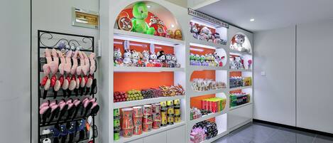 A retail space with shelves stocked with plush toys, hats, and packaged goods.
