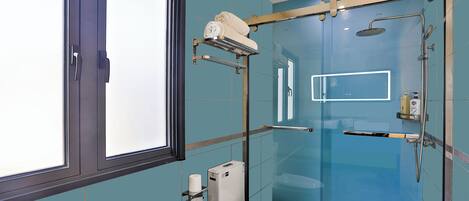 Een moderne badkamer met een douchecabine van glas, een toilet en een handdoekhouder.