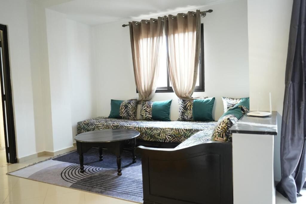 A small, modern room with a sofa, a round table, and a desk.