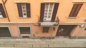 Ein Gebäude mit Balkon, Fensterläden und einer Tür.