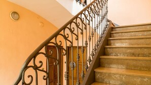 Eine Treppe mit aufwendiger Metallreling und Holzstufen.