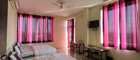 A hotel room with a large bed, a desk, and a chair.