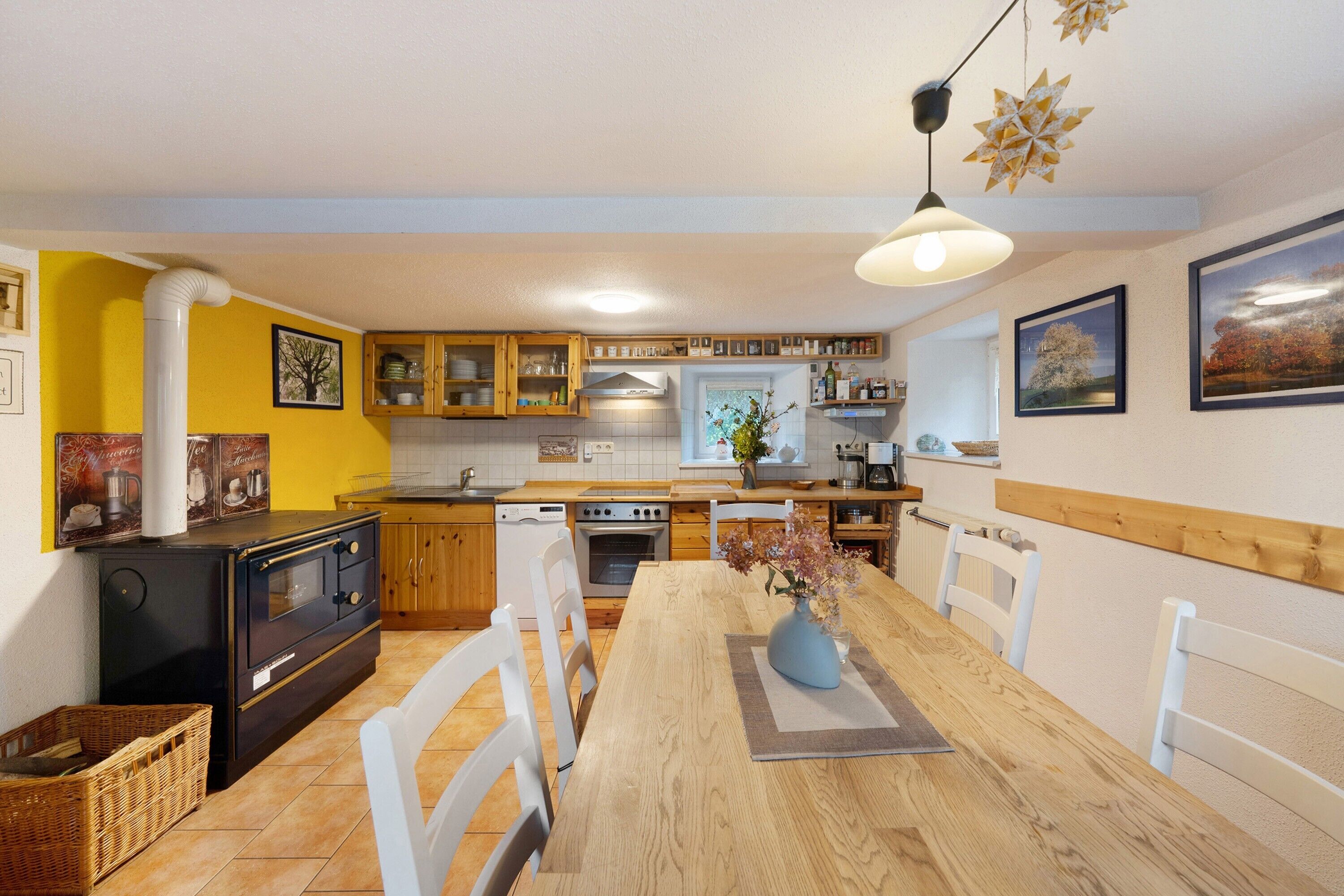 A kitchen with a dining table, chairs, a stove, and a sink.