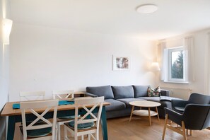 A living room with a sofa, two chairs, a small table, and a window with curtains. - Apartment 'Tannenblick 6-2' with Mountain View, Balcony and Wi-Fi (Oberhof)