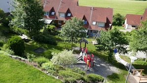 Ein Wohngebiet mit Häusern, einem Spielplatz und einem gepflegten Garten.