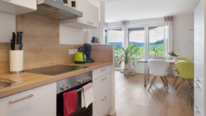 Eine moderne Küche mit einer Holzarbeitsplatte, Edelstahlgeräten und Blick ins Freie.