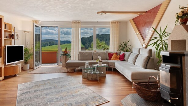 Een moderne woonkamer met een bank, televisie en open haard.