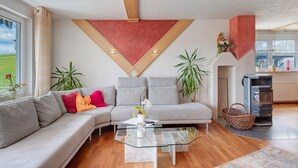 Een moderne woonkamer met een modulaire bank, een glazen salontafel en een open haard.