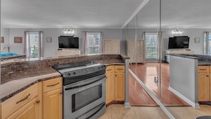A modern kitchen with granite countertops, stainless steel appliances, and wooden cabinets. - Honky Tonk Angels Suite (Nashville)